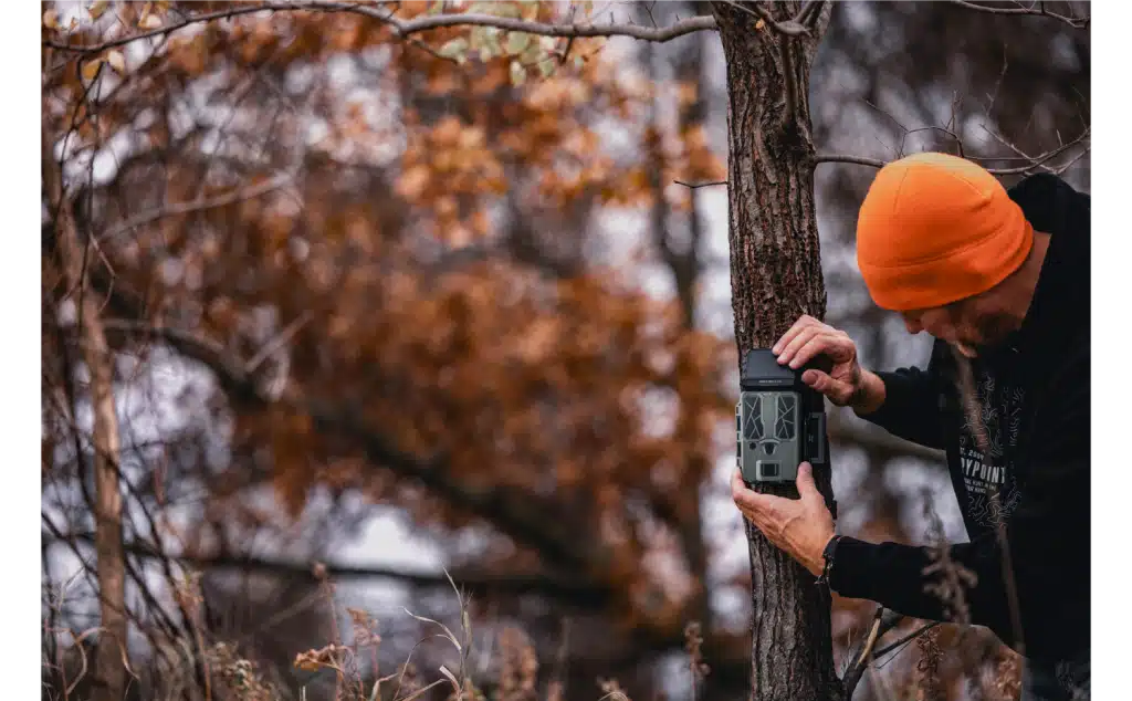 Spypoint trail camera being set up in the woods